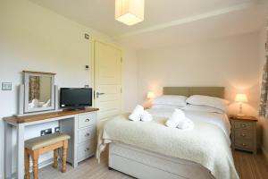 1 dormitorio con 1 cama, TV y espejo en Northrawe, en Bamburgh
