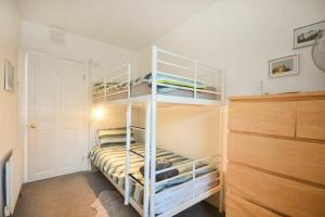 Crier Cottage في ألنويك: غرفة نوم بسريرين بطابقين في غرفة