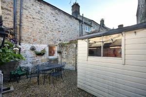 a patio with a table and chairs next to a building at Crier Cottage in Alnwick