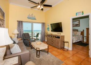 uma sala de estar com um sofá e uma televisão de ecrã plano em Crystal Shores 204 em Gulf Shores