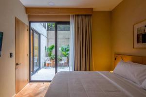 1 dormitorio con 1 cama y puerta corredera de cristal en Ana Polanco Apartments, en Ciudad de México