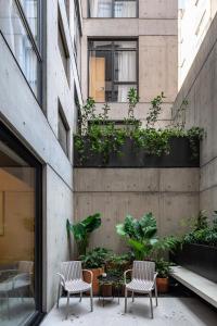 due sedie e un tavolo di fronte a un edificio di Ana Polanco Apartments a Città del Messico