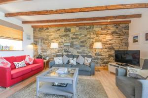 a living room with two couches and a stone wall at Farne Lookout in Seahouses