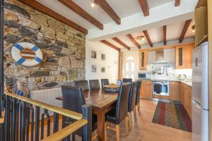 a kitchen with a wooden table and a stone wall at Farne Lookout in Seahouses