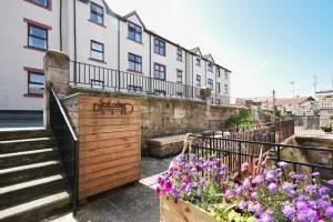 a building with stairs and flowers in front of it at Farne Lookout in Seahouses
