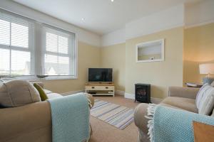 uma sala de estar com 2 sofás e uma televisão de ecrã plano em Coastal Haven em Seahouses