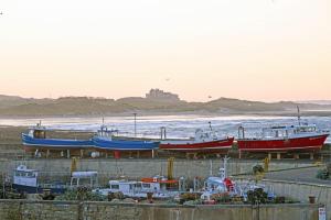 um grupo de barcos estacionados junto ao oceano em Coastal Haven em Seahouses