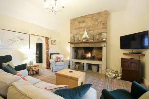 a living room with a couch and a fireplace at Charlton Cottage in Bamburgh