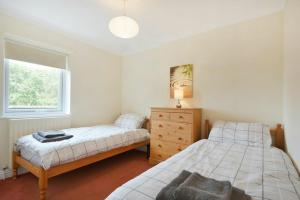 1 dormitorio con 2 camas y ventana en Decked Out, en Alnmouth