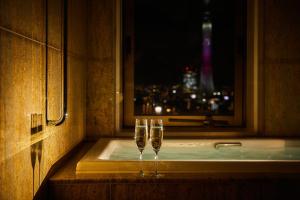 東京にある浅草ビューホテルの窓際の棚に座るグラス2杯