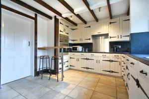 a large kitchen with white cabinets and a counter at Friars Court in Alnmouth