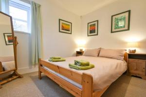 een slaapkamer met een bed met groene handdoeken erop bij Friars Court in Alnmouth