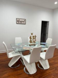 a dining room with a glass table and white chairs at Cheerful 3 Bedrooms kitchen/dining/private office in Columbus