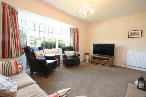 a living room with two chairs and a flat screen tv at Inveray in Seahouses