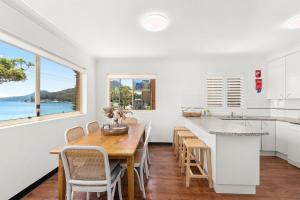 a kitchen and dining room with a table and chairs at South Pacific Unit 5 13 Shoal Bay Road in Shoal Bay