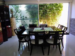 comedor con mesa, sillas y ventana en Habitación matrimonial con cama y sofá para cuatro personas en Tlaxcalancingo