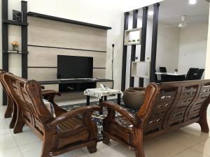 a living room with two chairs and a television at Koolest homestays Meru in Ipoh