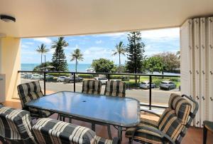 einen Tisch und Stühle auf einem Balkon mit Meerblick in der Unterkunft Coral Sands Apartment 201 in Bargara