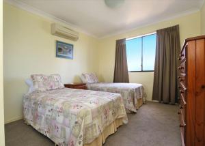 ein Hotelzimmer mit 2 Betten und einem Fenster in der Unterkunft Coral Sands Apartment 201 in Bargara