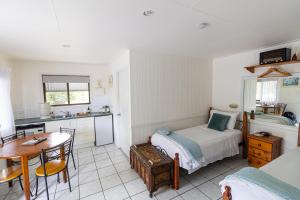 a bedroom with a bed and a table and a kitchen at Chillagoe Cabins and Tours in Chillagoe