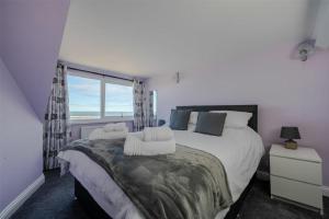 a bedroom with a large bed and a window at Lobster Lodge in Seahouses