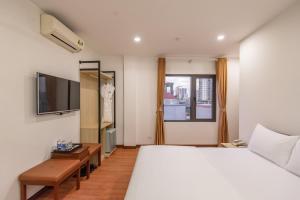 1 dormitorio con 1 cama grande y TV en Coco Hotel Cau Giay en Hanoi