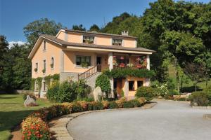 a large house with flowers in front of a driveway at Santu Colás in Corao