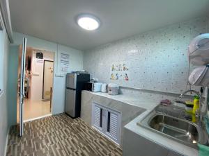 a small kitchen with a sink and a refrigerator at NB Bangsaen House in Ban Puk (2) +23 photos
