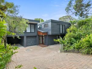 una casa negra con una entrada delante de ella en 11 Attunga Heights Noosa Heads, en Noosa Heads
