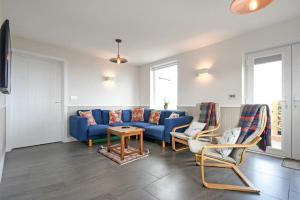 a living room with a blue couch and chairs at Eastfield in Embleton