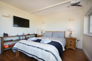 a bedroom with two beds and a tv on the wall at Eastfield in Embleton