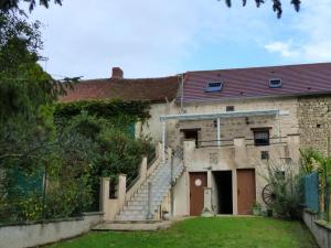 una antigua casa de piedra con un conjunto de escaleras en Gîte Saint-Germain-de-Salles, 3 pièces, 4 personnes - FR-1-489-96, en Saint-Germain-de-Salles