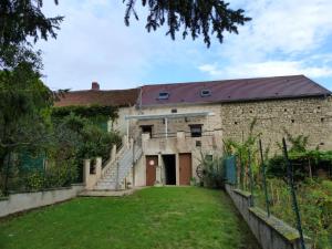 Un antiguo edificio de ladrillo con una escalera que conduce a un patio. en Gîte Climatise Près de la Sioule avec Jardin Privatif, Terrasse et Tout Confort - FR-1-489-96, en Saint-Germain-de-Salles 10 fotos más