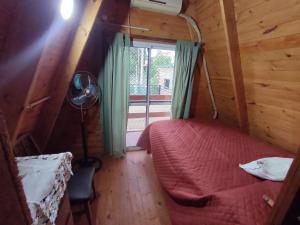 um quarto com uma cama e um candeeiro numa cabina em Alpina La Luna em Valle Hermoso