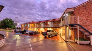 a building with cars parked in a parking lot at Canowindra Riverview Motel in Canowindra
