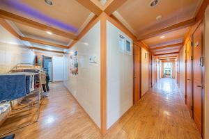 a hallway with white tile walls and a wooden ceiling at Dream Single House in Seoul