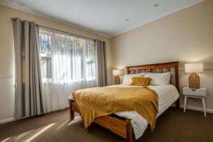 1 dormitorio con cama y ventana grande en Viewhill Holiday Units - Bright en Bright