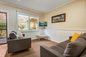 a living room with a couch and two chairs at Viewhill Holiday Units - Bright in Bright