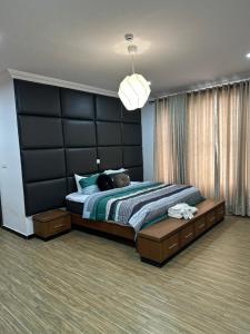 una camera con un grande letto con testiera nera di Nigus House Oniru a Lagos