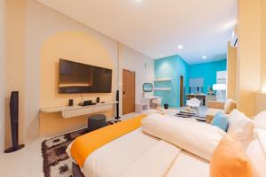 a bedroom with a large bed with a tv on the wall at Sans Hotel Alexander Bandung in Bandung