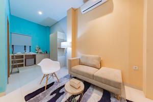 a living room with a couch and a chair at Sans Hotel Alexander Bandung in Bandung