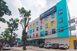 a building with cars parked in front of it at Sans Hotel Alexander Bandung in Bandung