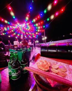 a table with donuts and bottles of beer and lights at Norvinton Hotel in Batu Pahat