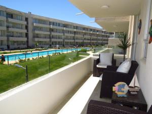 an apartment balcony with a view of a swimming pool at Departamento AltoMar El Tabo Isla Negra in El Tabo
