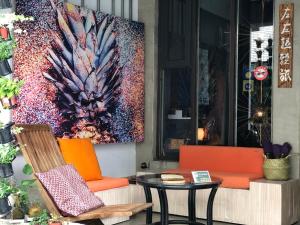 une terrasse avec 2 chaises, une table et un tableau dans l'établissement Zozola, à Hengchun Old Town