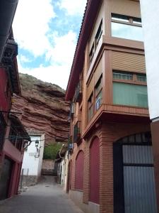 Une allée avec un bâtiment à côté d'une montagne dans l'établissement Hostal Ciudad de Nájera, à Nájera