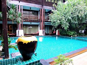een zwembad in een gebouw met een grote vaas ernaast bij Yantarasri Resort in Chiang Mai