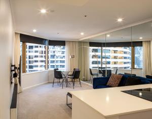 uma sala de estar com um sofá azul e uma mesa em Quay West 1301 Self- Catering em Sydney