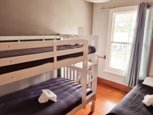 a bedroom with two bunk beds and a window at HarbourView Hotel in Raglan