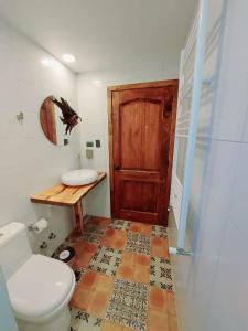 a bathroom with a toilet and a wooden door at Morrena Lodge in Torres del Paine